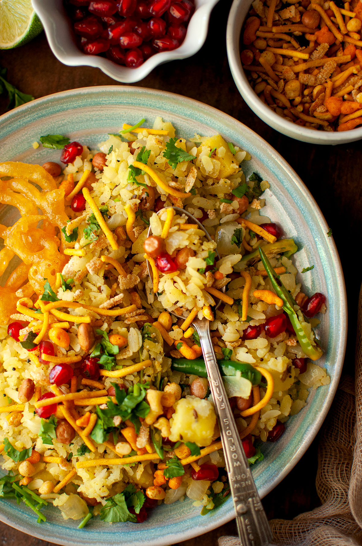 Blue plate with poha and a spoon.