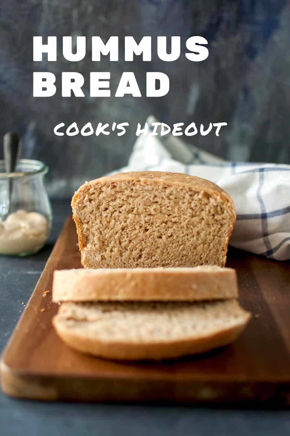 Chopping board with a loaf of humus bread slices