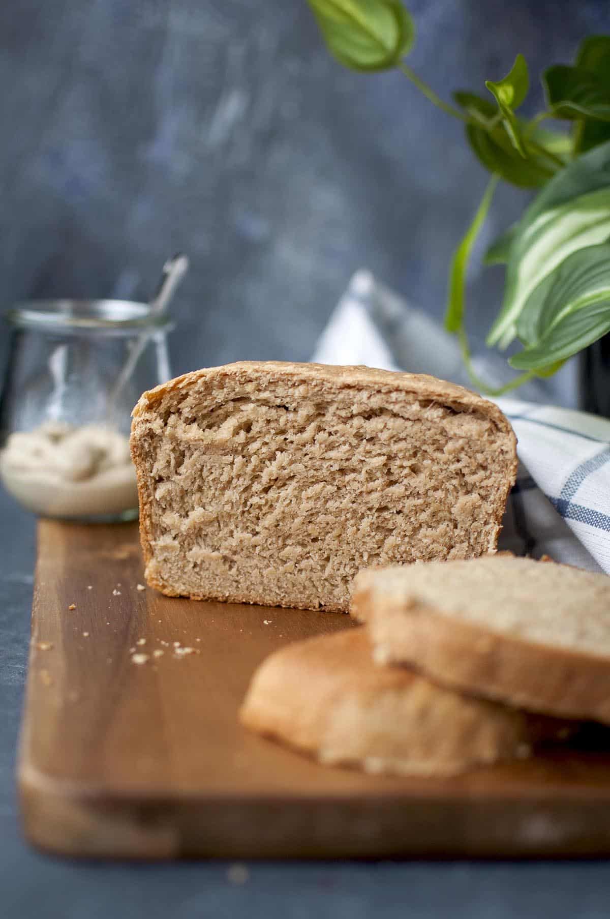 Chopping board with a loaf of humus bread slices