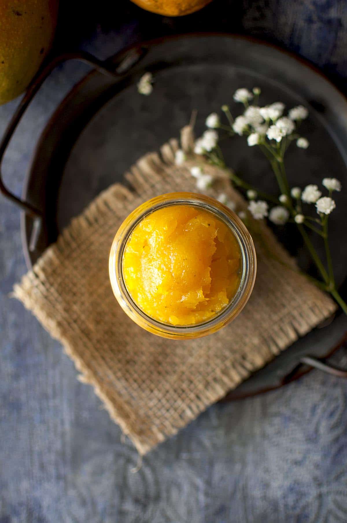 Top view of a glass jar with mango jam on a Tray