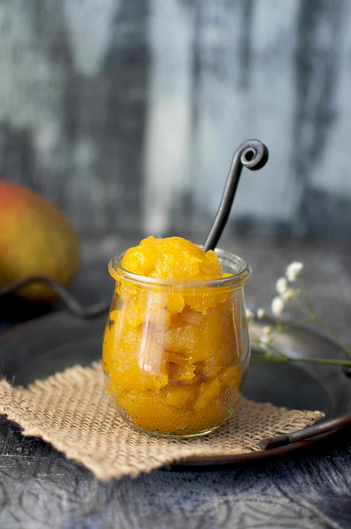 glass jar with mango jar with a spoon inside