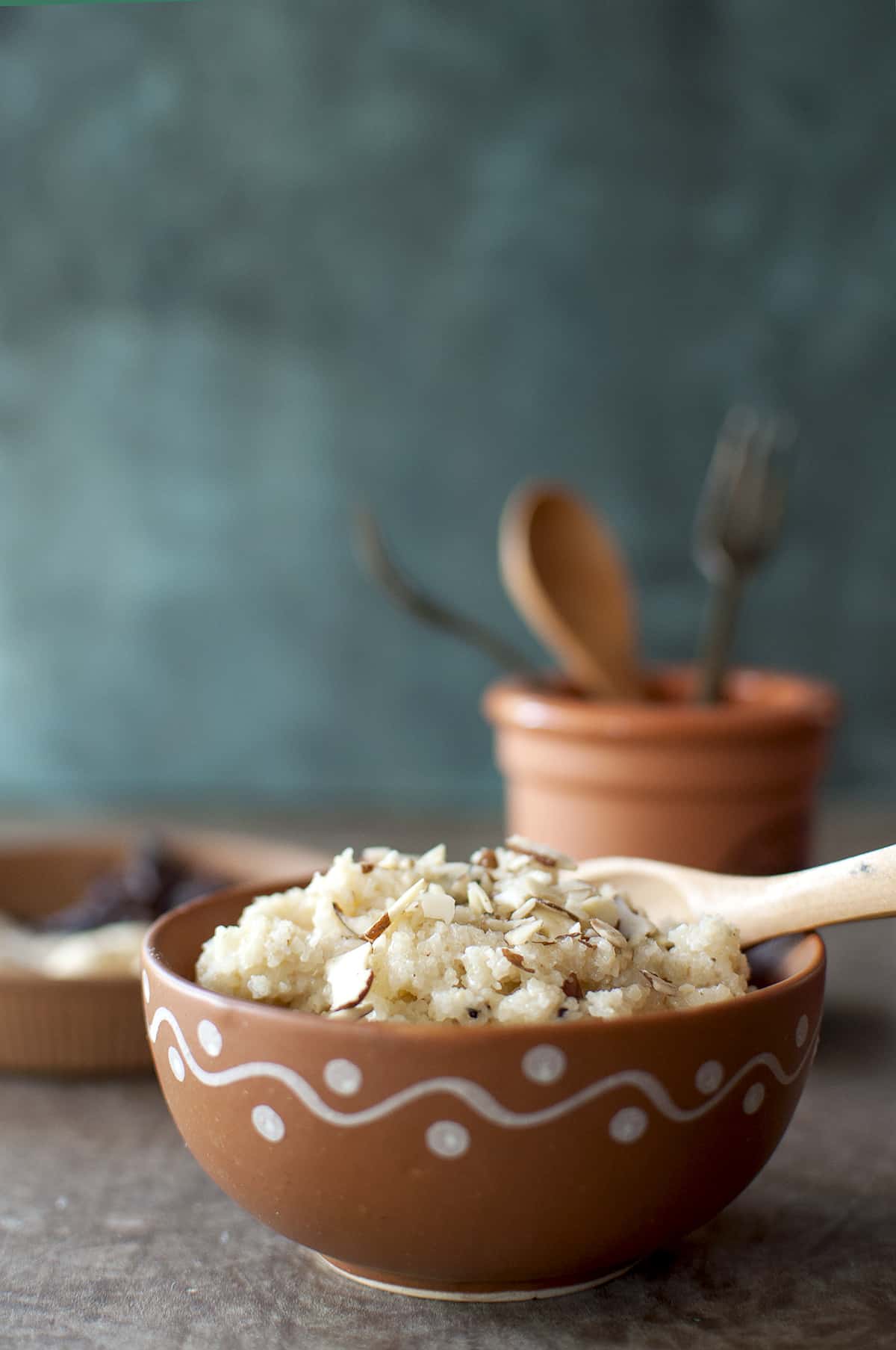 Terracotta bowl with rava kesari topped with almond flakes