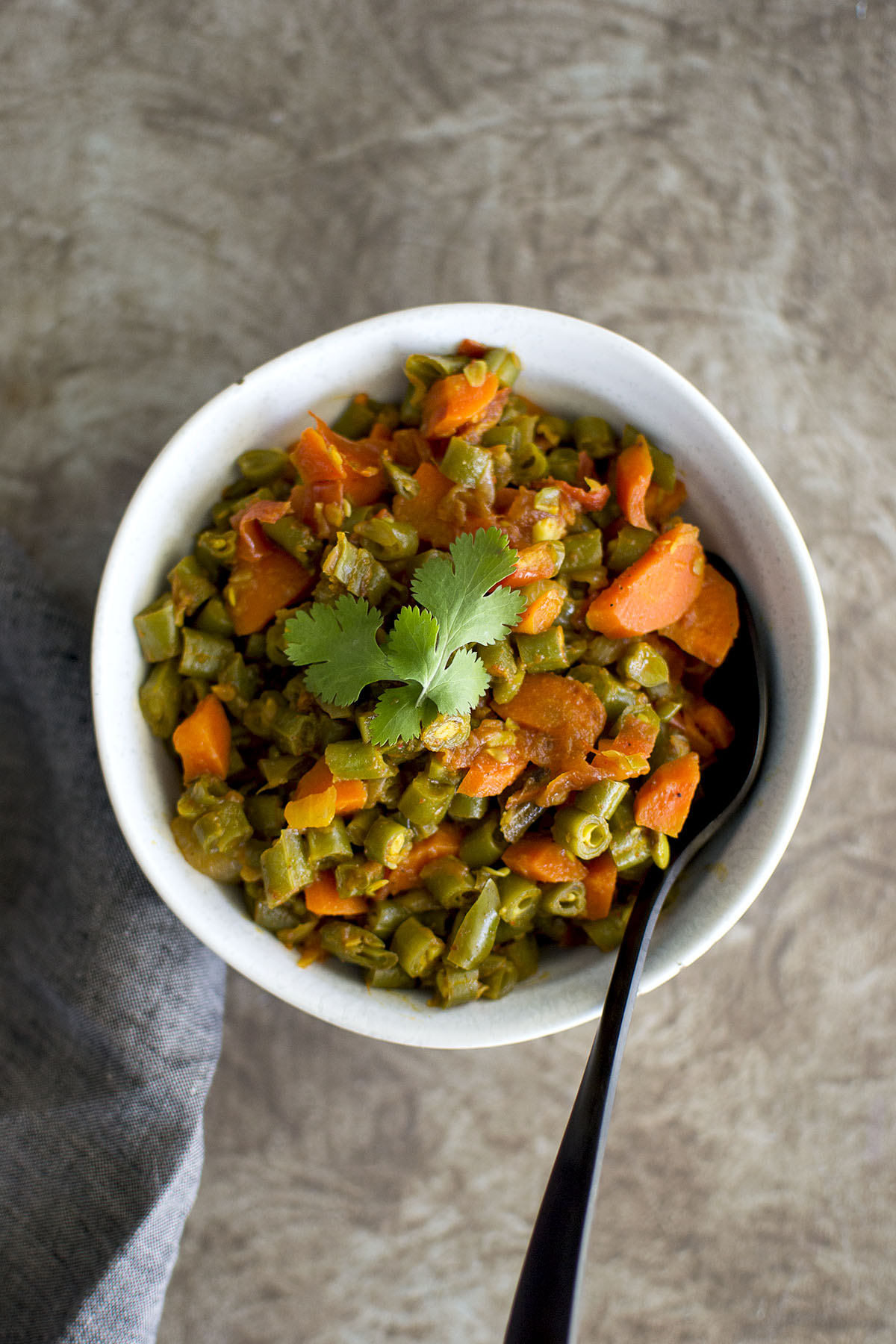 White bowl with green beans and carrot stir fry