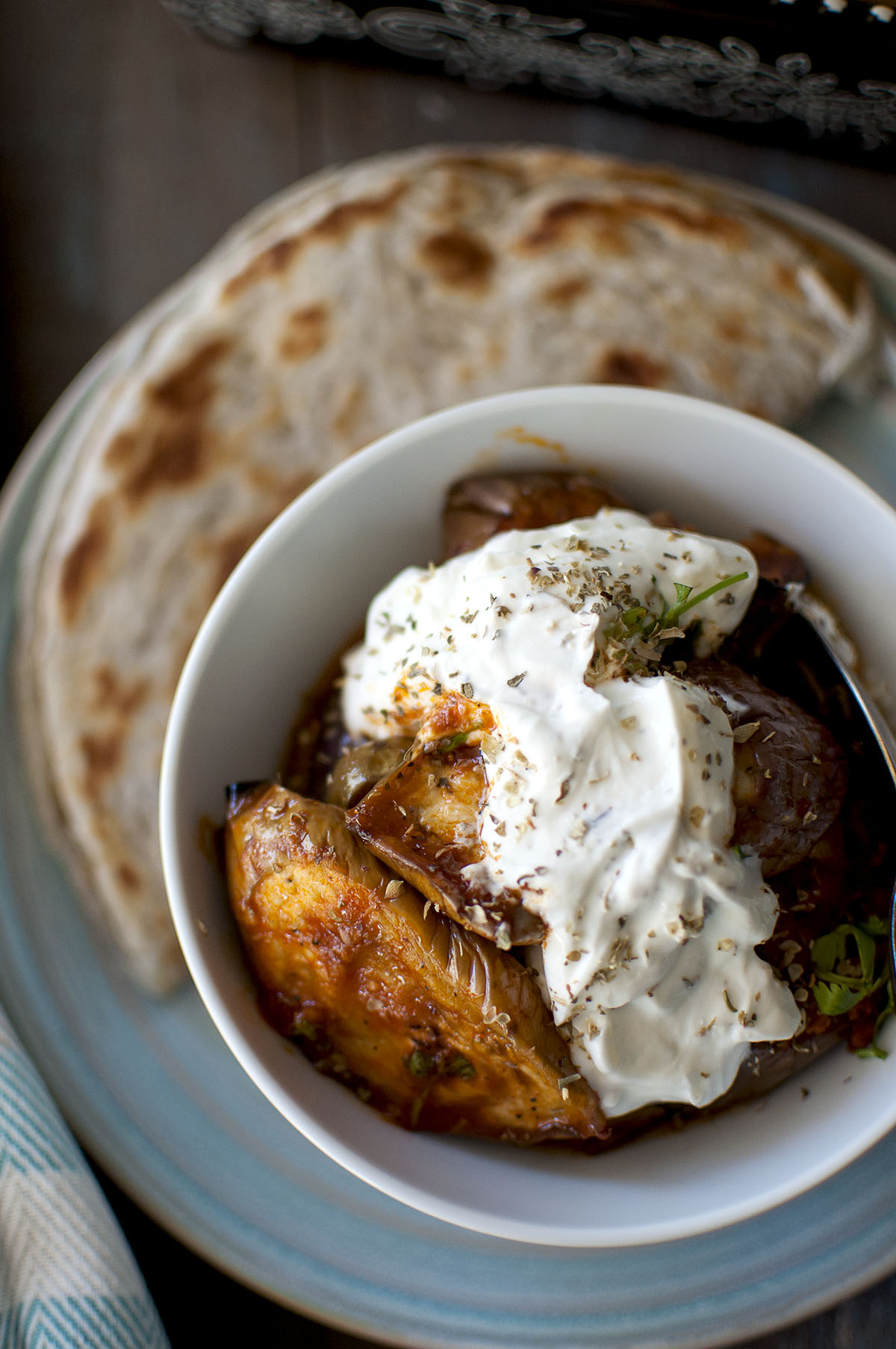 White bowl with Borani banjan and flatbread.