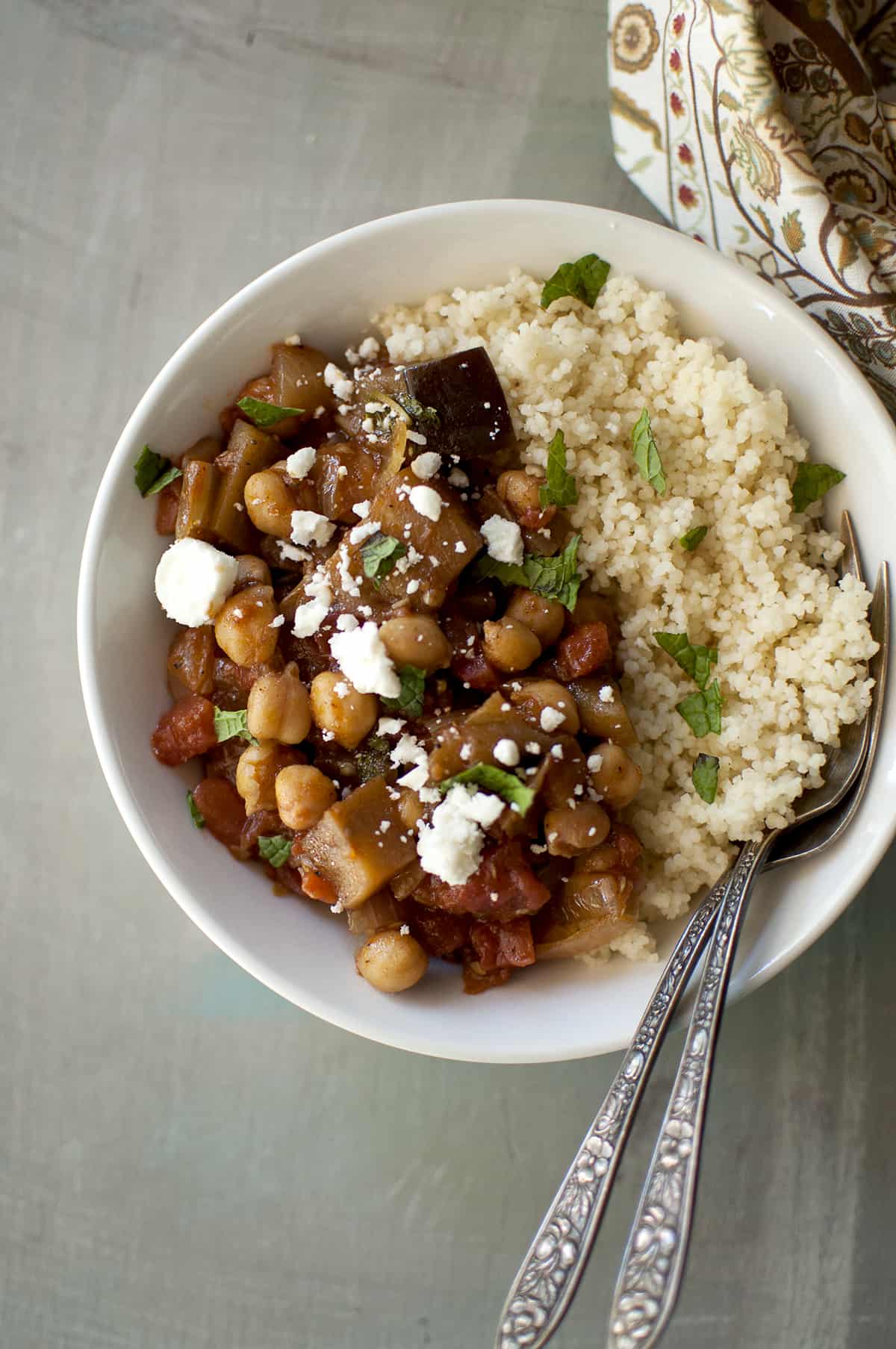 White bowl with eggplant and chickpea stew served with couscous