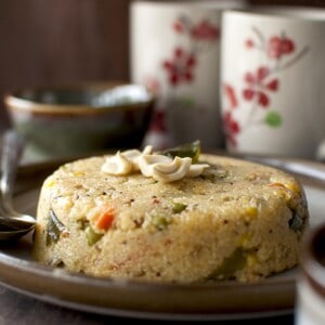 Brown plate with jowar upma topped with cashews