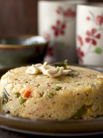 Brown plate with jowar upma topped with cashews