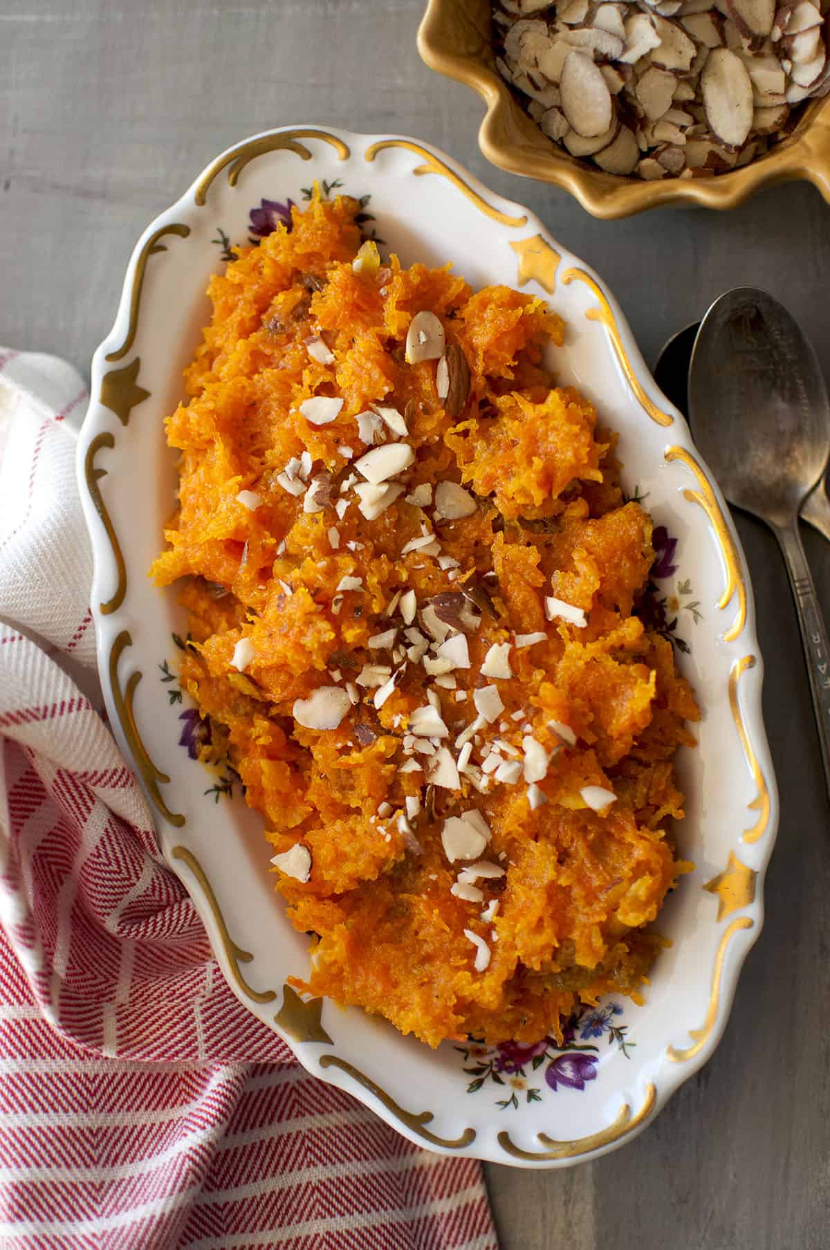 White oval bowl with Afghani carrot halwa topped with almond slices