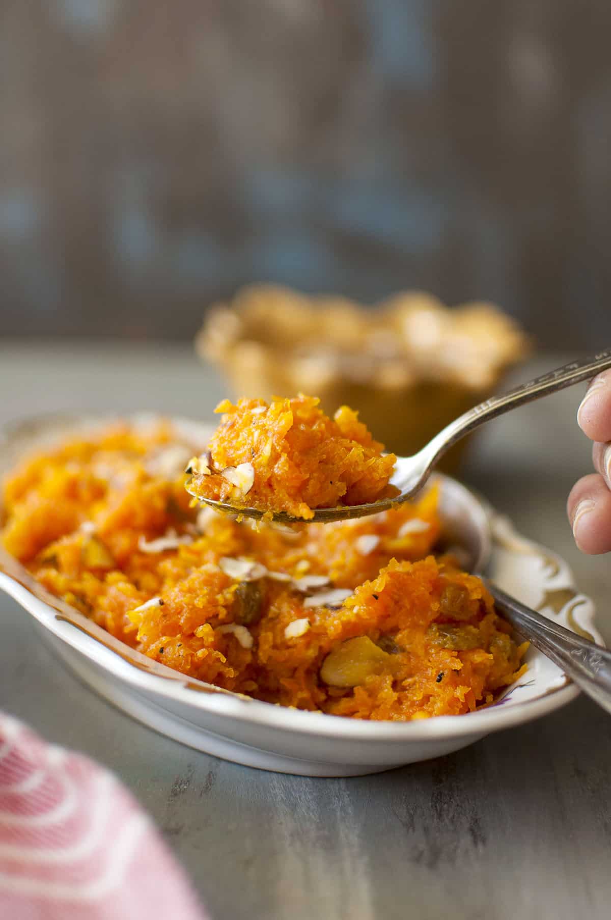 hand holding spoon with carrot halva