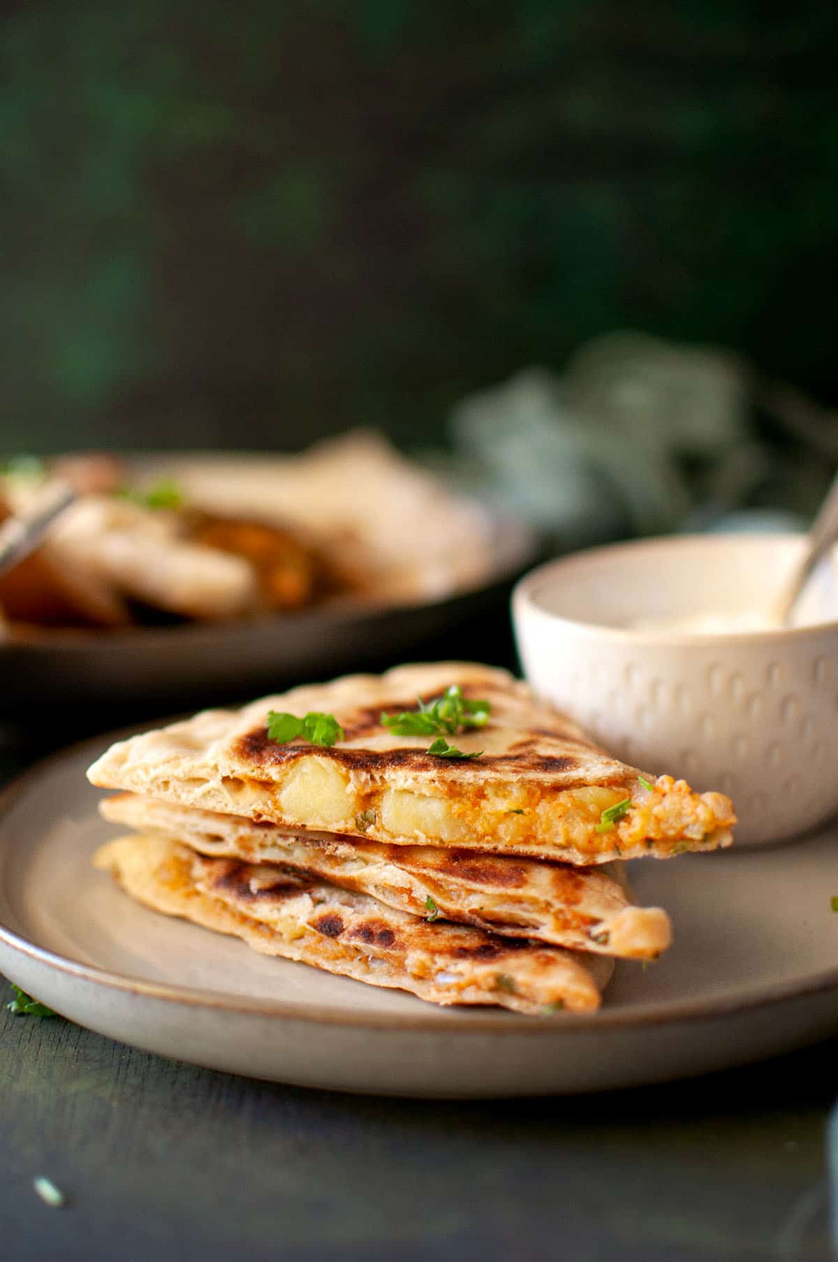 White plate with wedges of potato bolani.