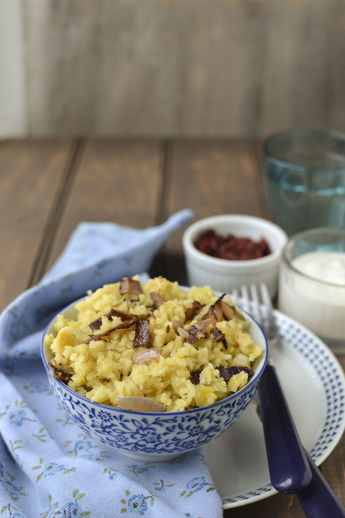 White bowl with Gujarati Khichdi topped with fried onions