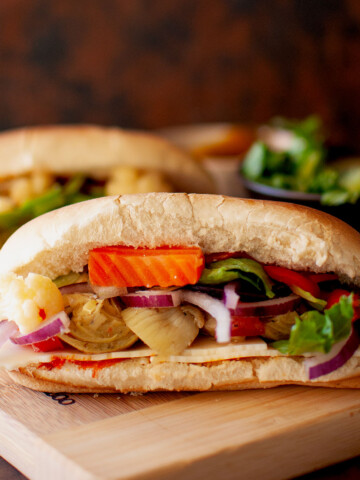 Chopping board with vegetarian hoagie sandwich.