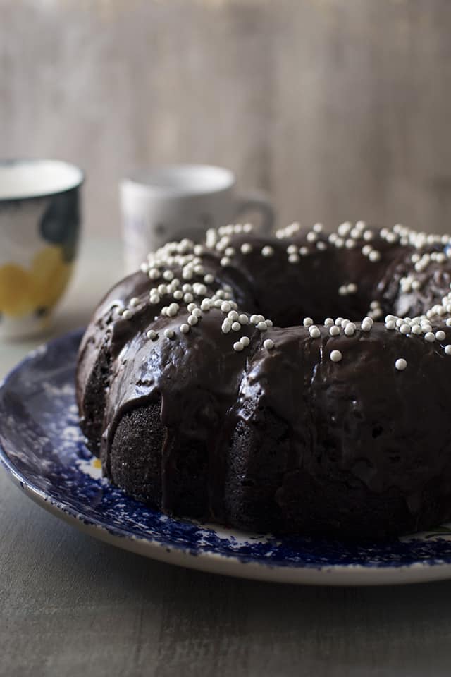 Plate with Chocolate Bundt Cake topped with chocolate icing and sugar pearls