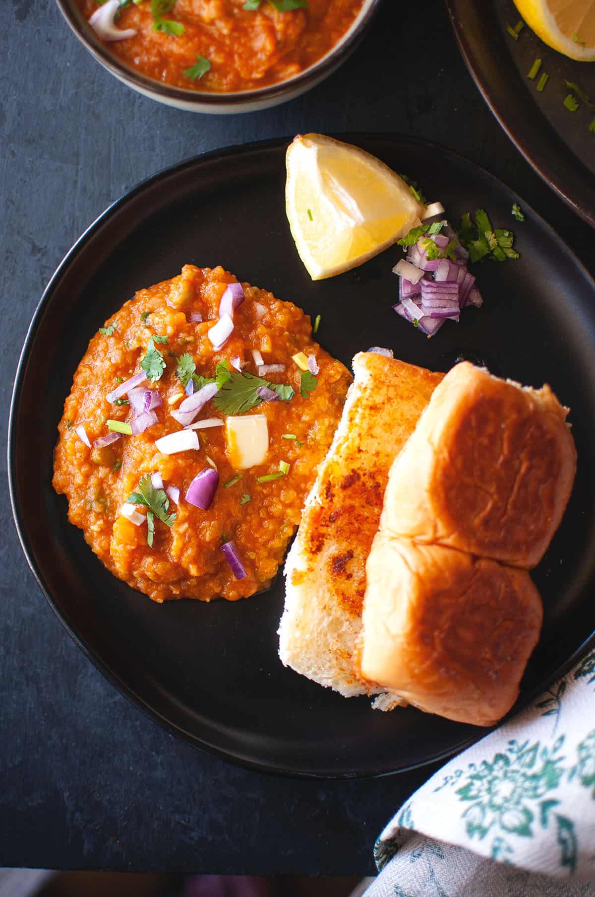 Black plate with pav bhaji.