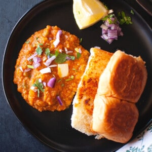 Black plate with pav bhaji.