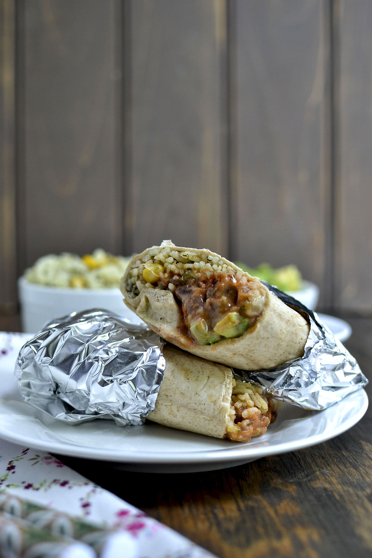 White plate with cheesy rice and beans burrito