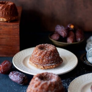 White plate with a mini eggless date cake.