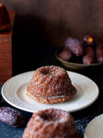 White plate with a mini eggless date cake.