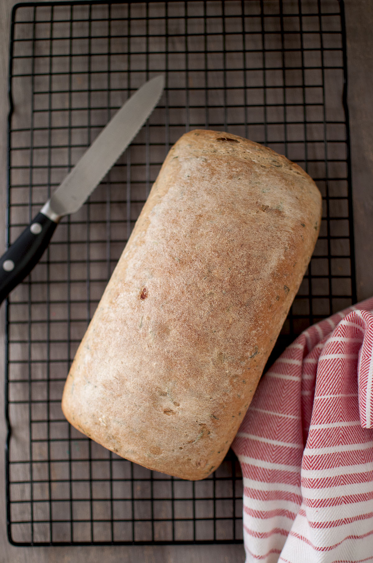 wire rack with loaf of bread and a knife