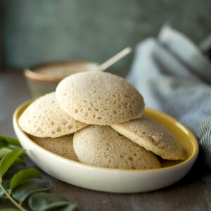 White plate with a stack of jowar idli.