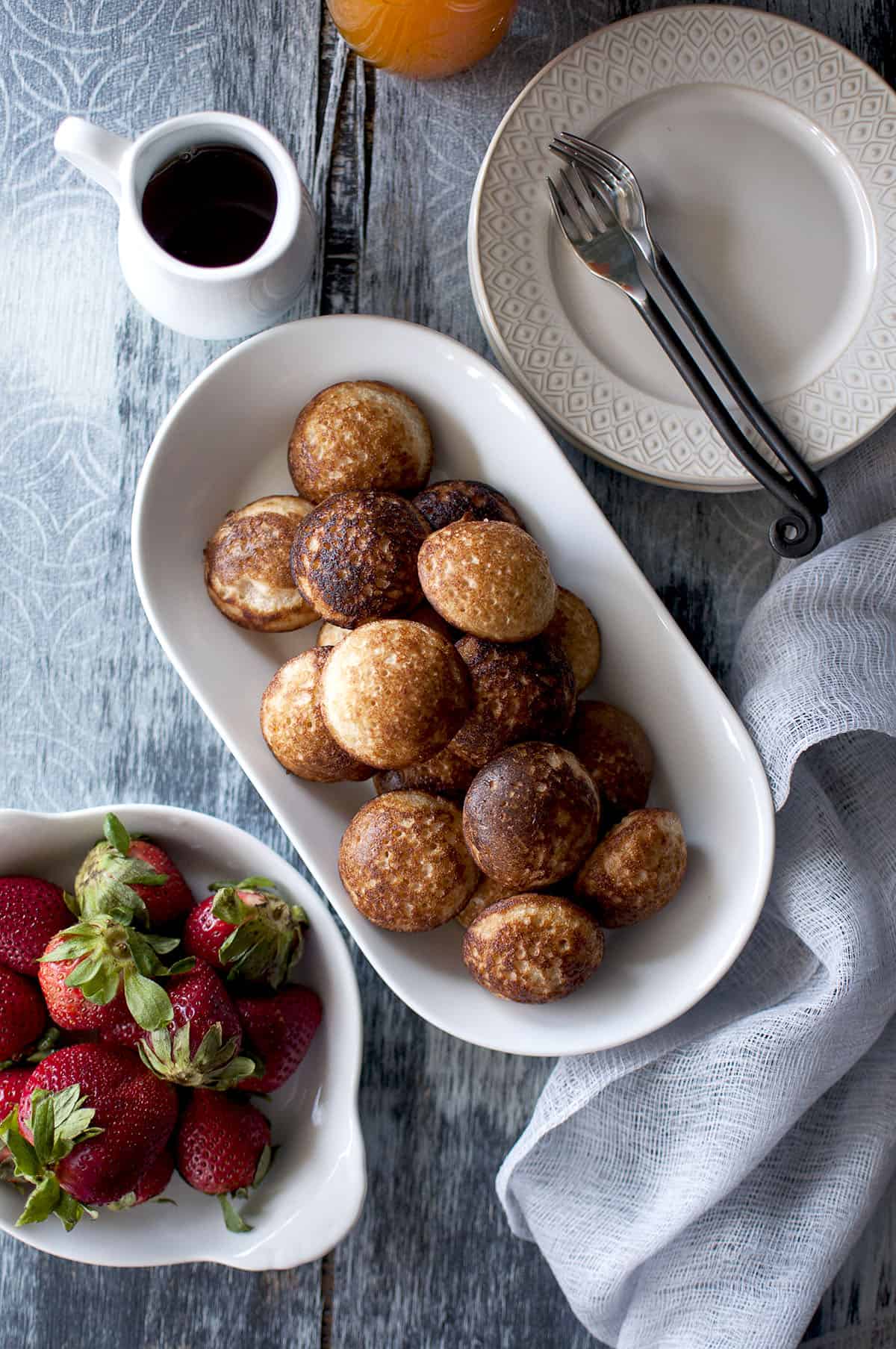 White bowl with mofo gasy and a white bowl with fresh strawberries