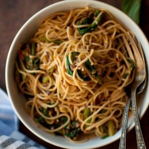 Top view of a white bowl with spaghetti and vegetables.