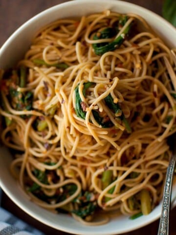 Top view of a white bowl with spaghetti and vegetables.