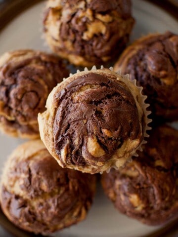 Top view of a white plate with a stack of banana muffins with nutella.