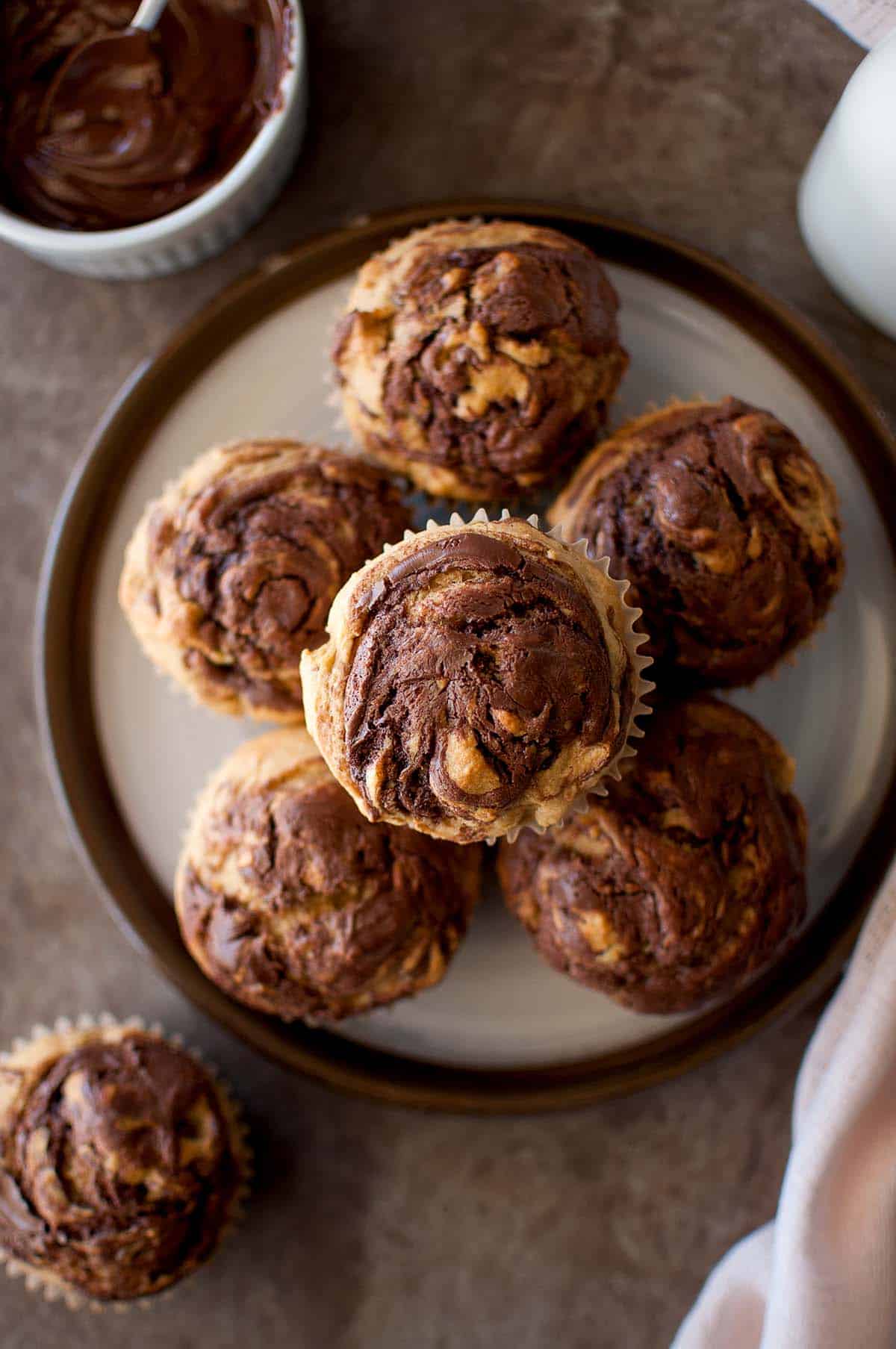 Top view of a white plate with a stack of nutella swirl muffins