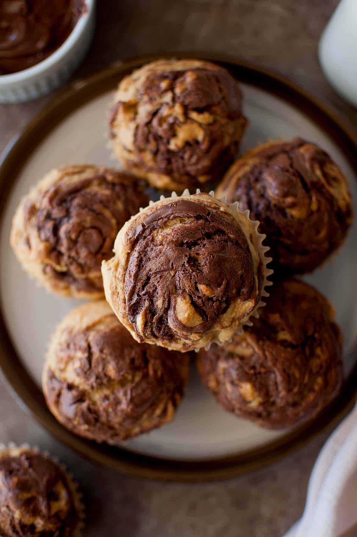 Top view of a white plate with a stack of banana muffins with nutella.