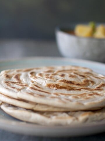 Blue plate with a stack of roti canai