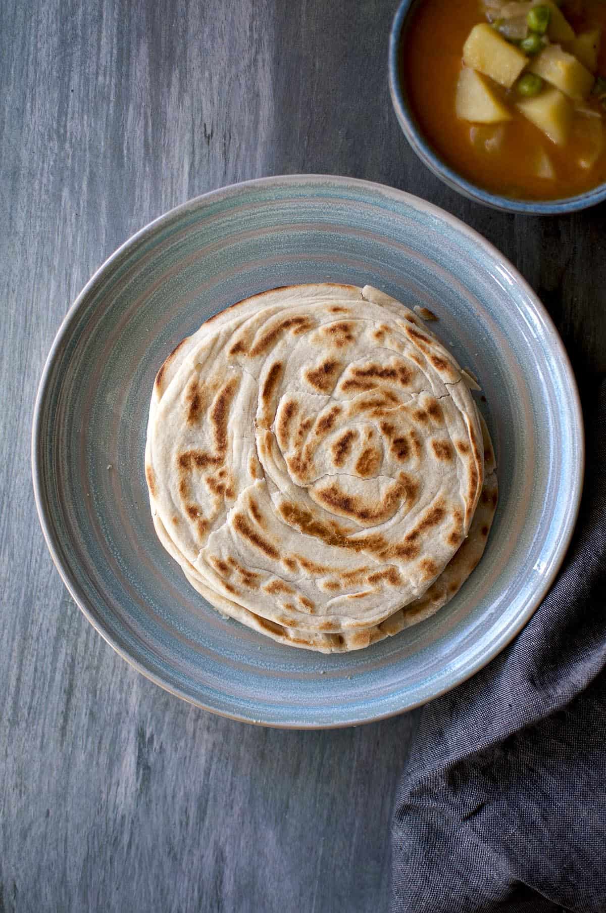 Blue plate with a stack of Roti Canai