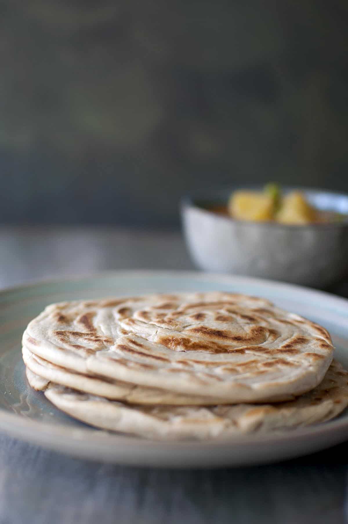 blue plate with a stack of roti canai