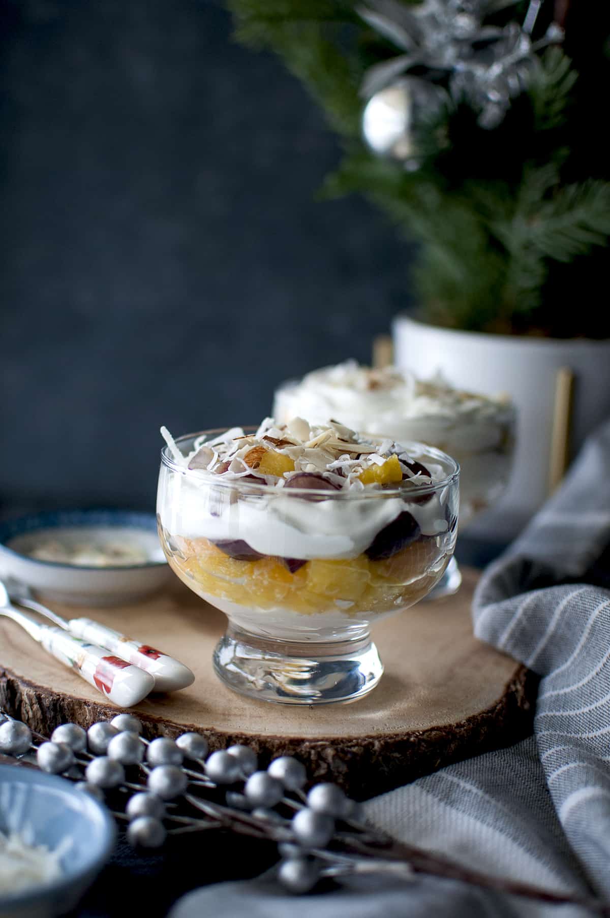 Ambrosia salad parfait served in glass serving cups placed on a wooden board