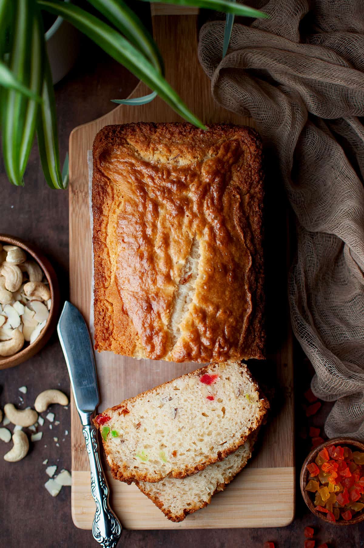 Top view of a eggless fruit nut cake on a chopping board.