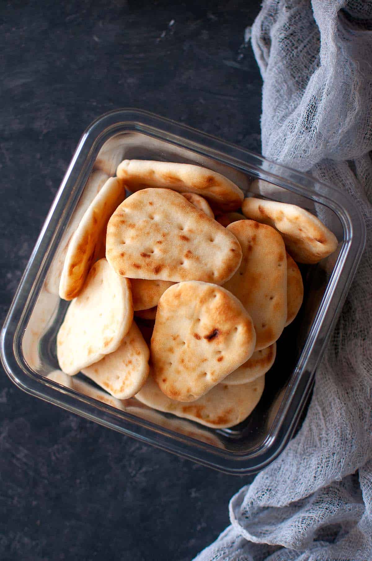 Plastic box with mini naan breads.