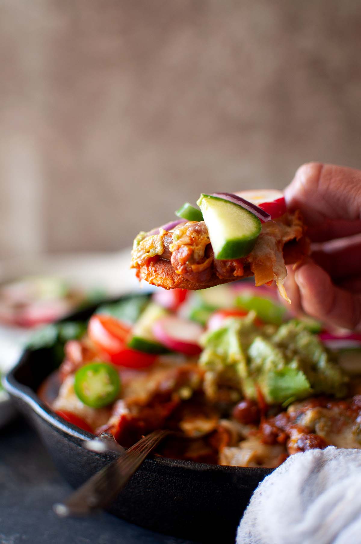 Hand holding a naan nacho.