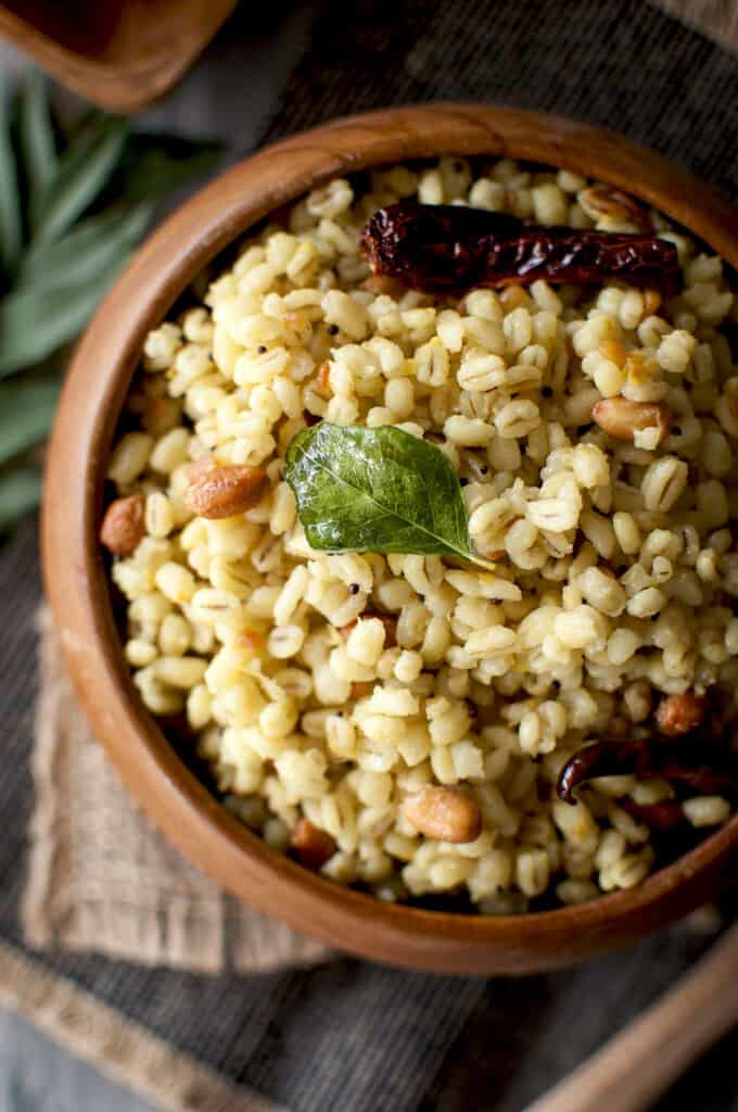 Wooden bowl with lemon flavored barley topped with peanuts