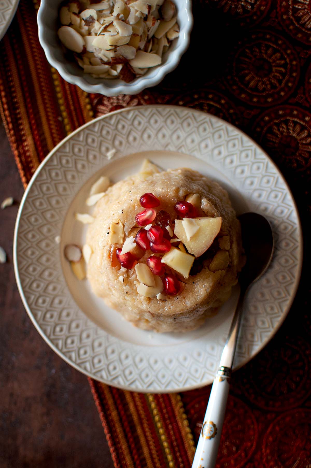 White plate with Jonna rava kesari topped with fruit