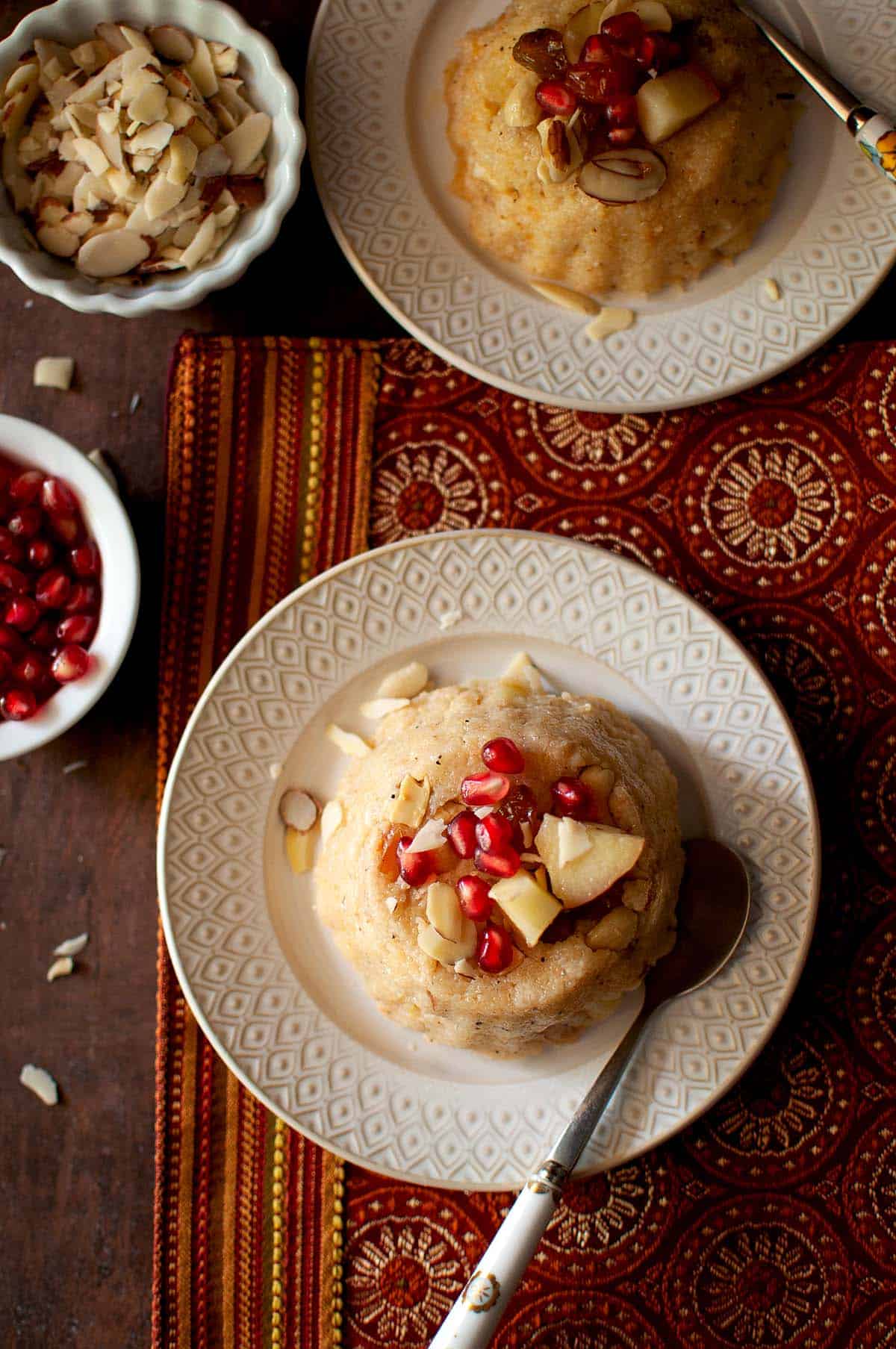 White plate with Jonna rava kesari topped with fruit