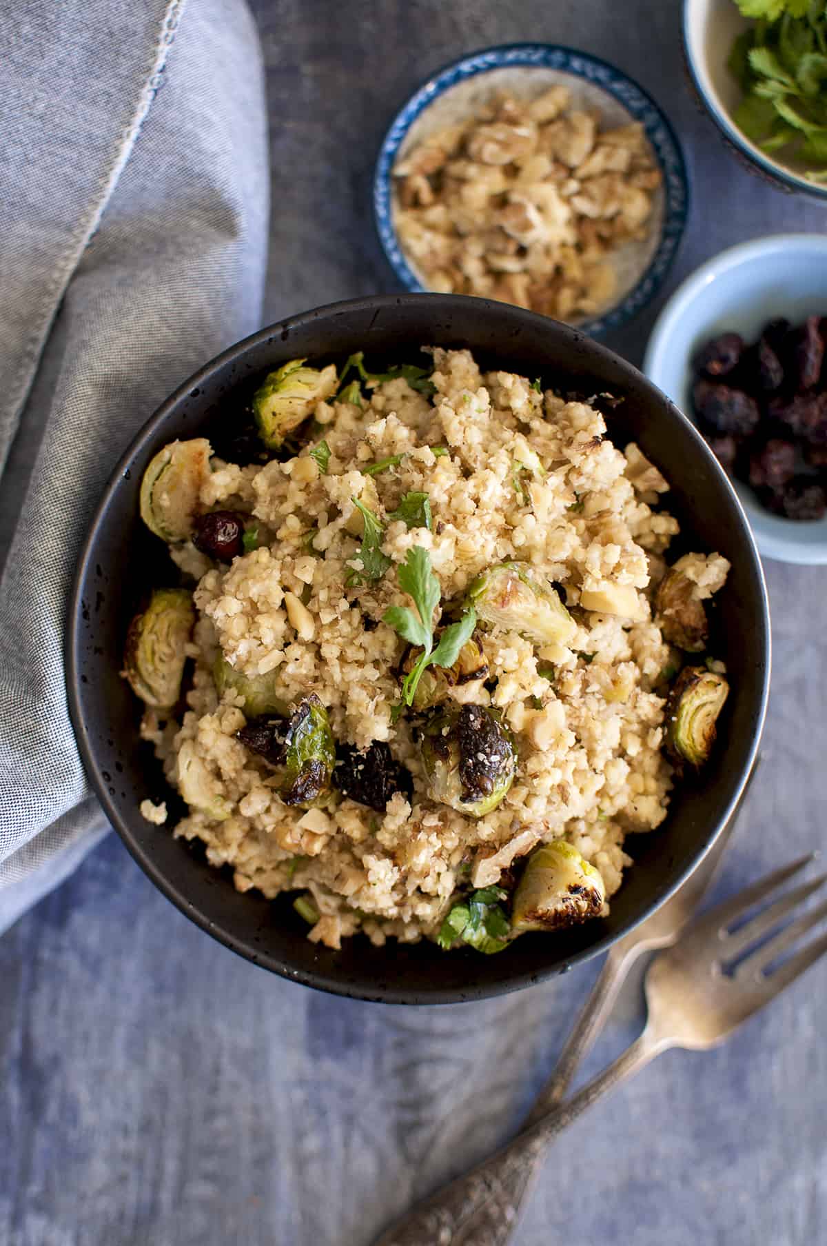 Black bowl with brussels sprouts salad with millet.