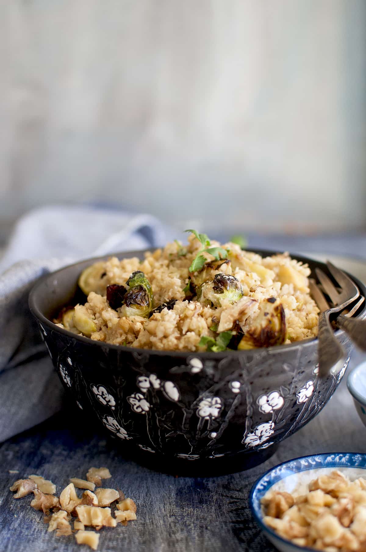 Black bowl with millet salad with walnuts.