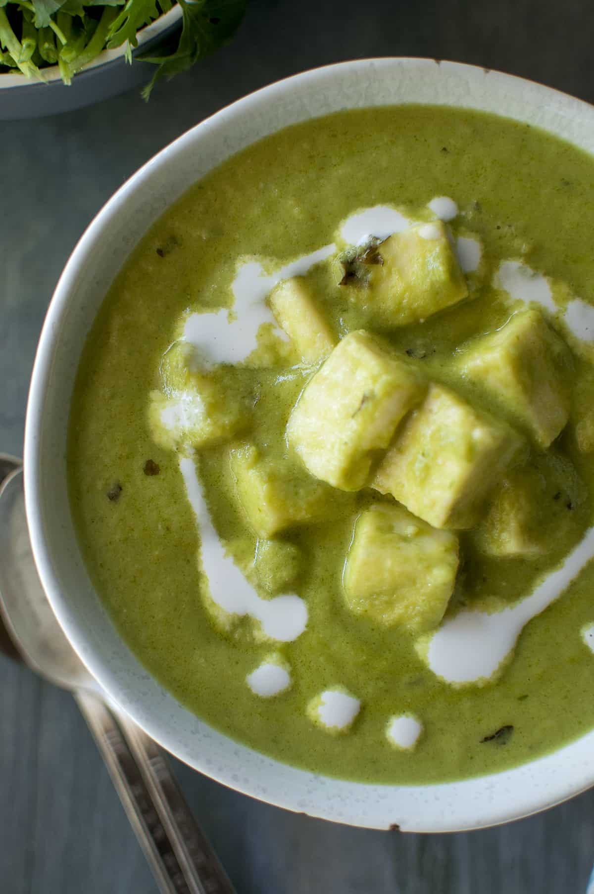 Grey bowl with green paneer curry