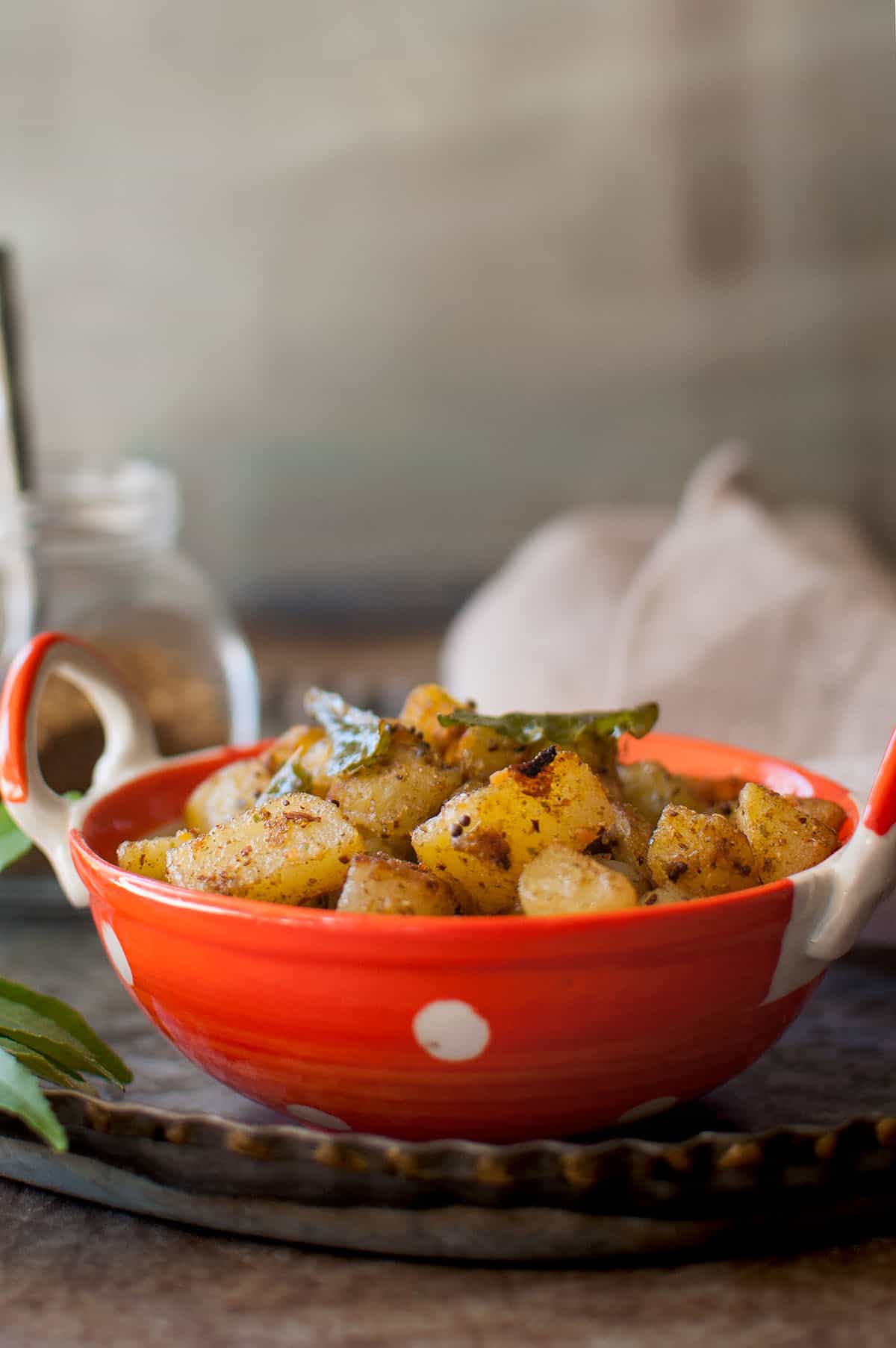 Orange bowl with dry potato curry.