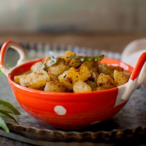 Orange bowl with dry potato curry.