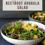 White bowl with beet and arugula salad.