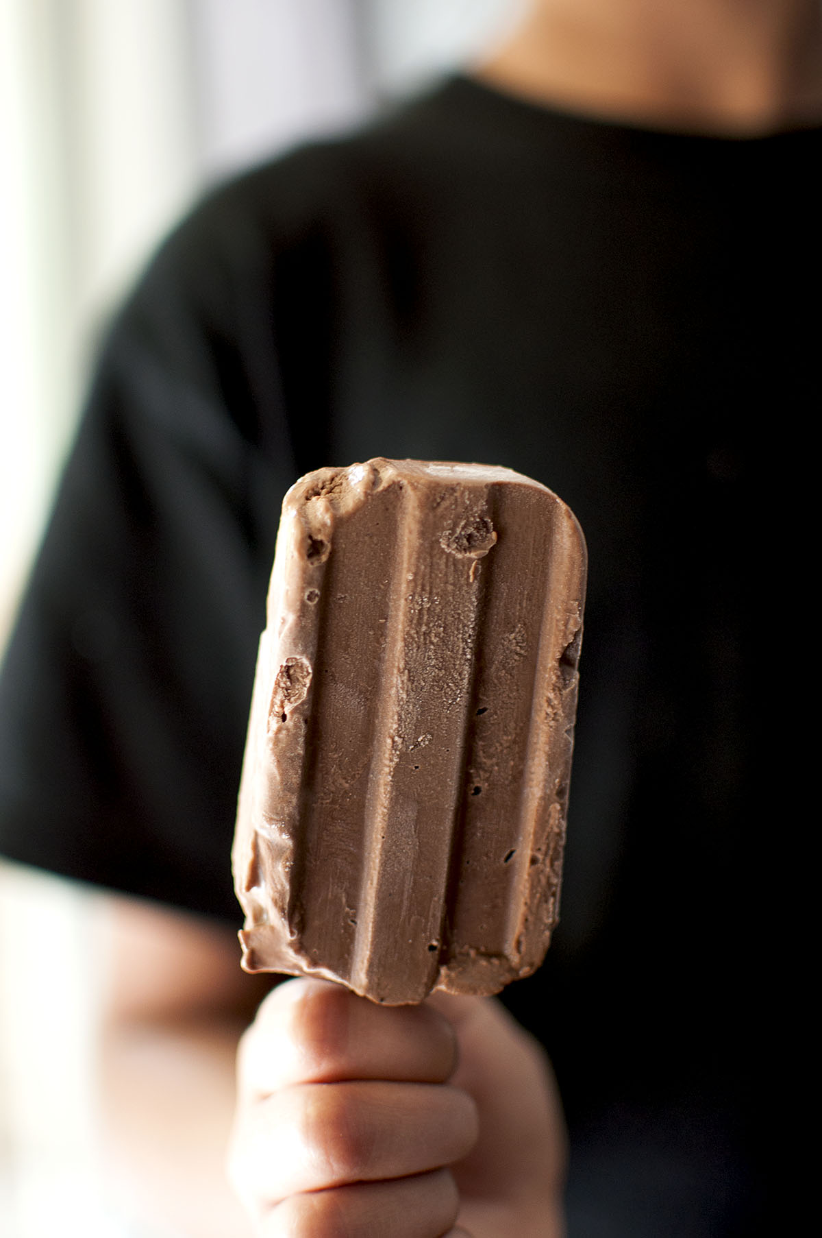 Hand holding a chocolate popsicle