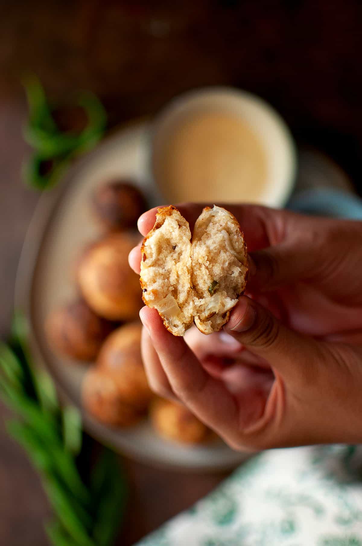 Hand holding halved paddu.