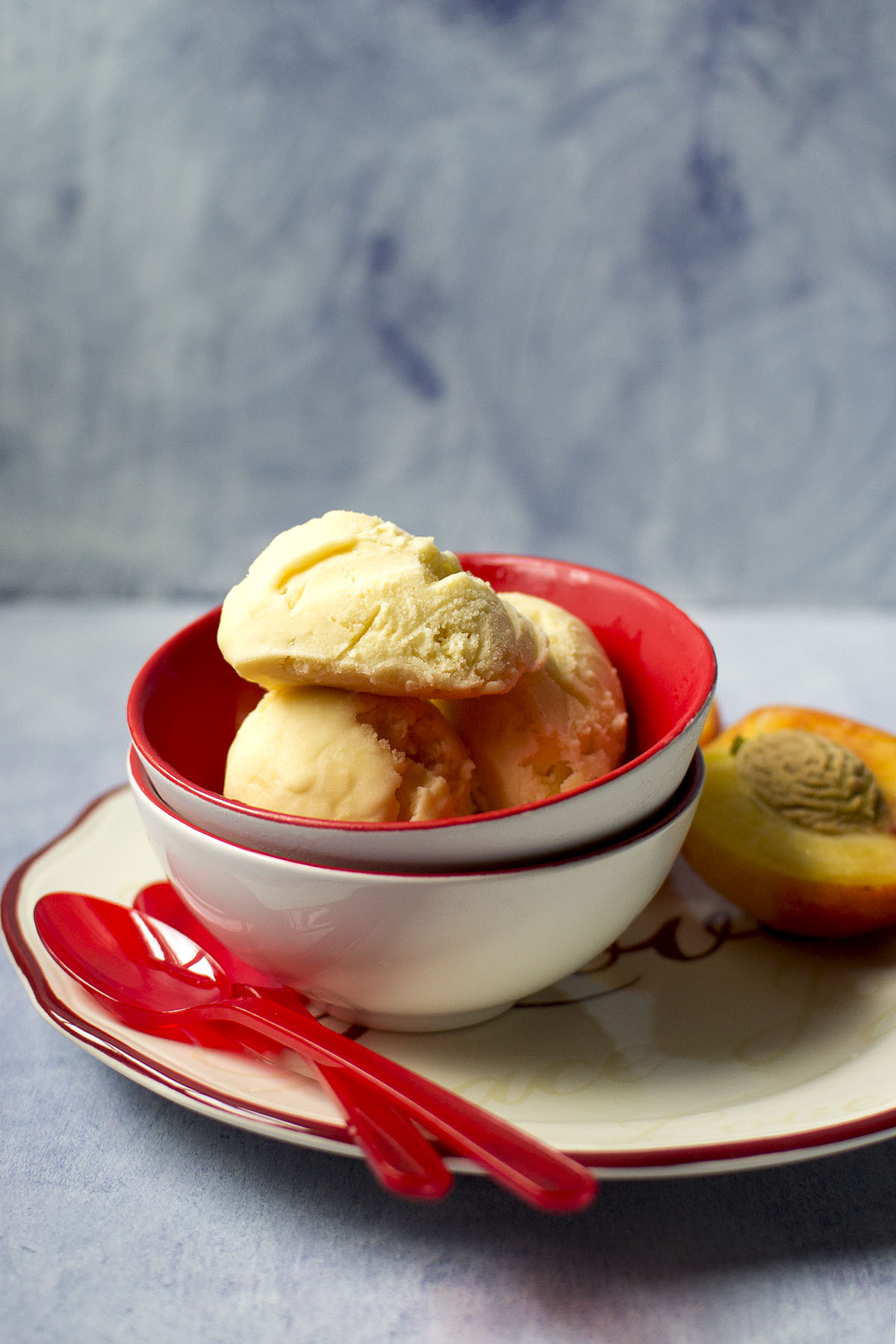 White bowl with 3 scoops of peach ice cream