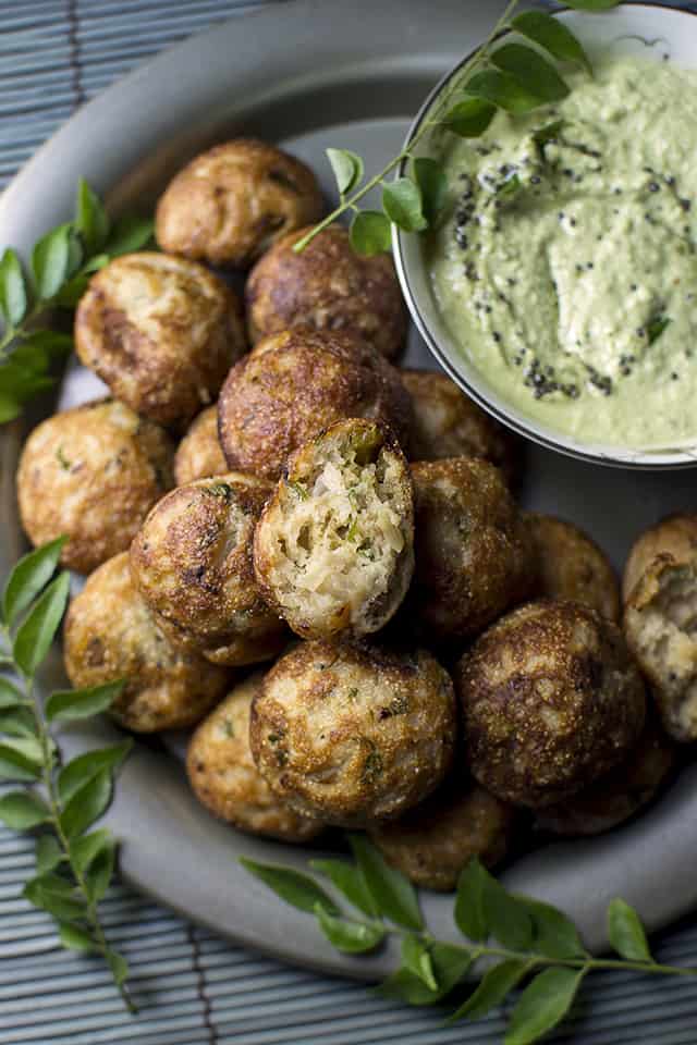 Pewter plate with a stack of south Indian savory aebleskivers and green chutney